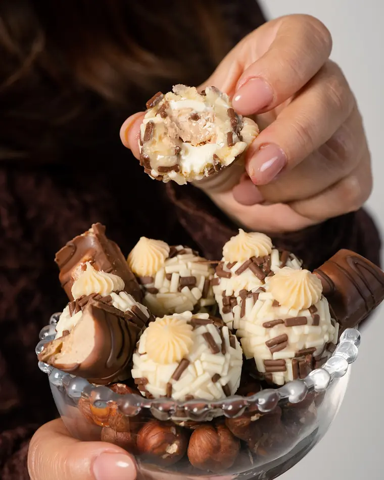 Mão tirando um brigadeiro gourmet da taça